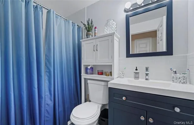 a bathroom with a sink vanity mirror and toilet