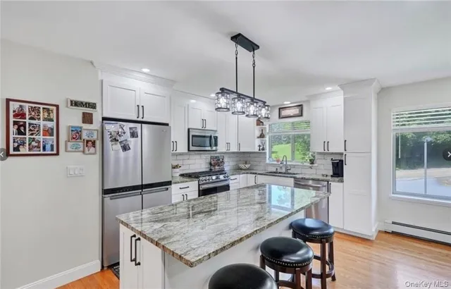 a kitchen with stainless steel appliances granite countertop a sink refrigerator and microwave