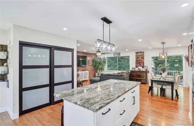 a kitchen with stainless steel appliances granite countertop a stove and a wooden floors