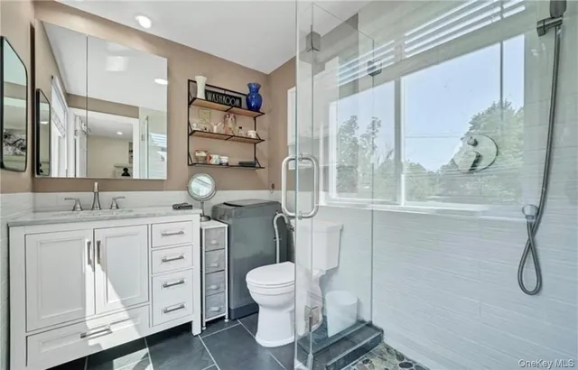 a bathroom with a double vanity sink toilet and shower