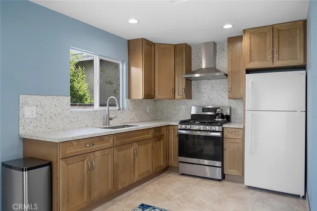 a kitchen with stainless steel appliances granite countertop a stove a refrigerator and a sink