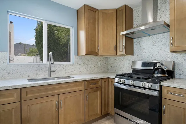 a kitchen with stainless steel appliances granite countertop a sink stove and cabinets