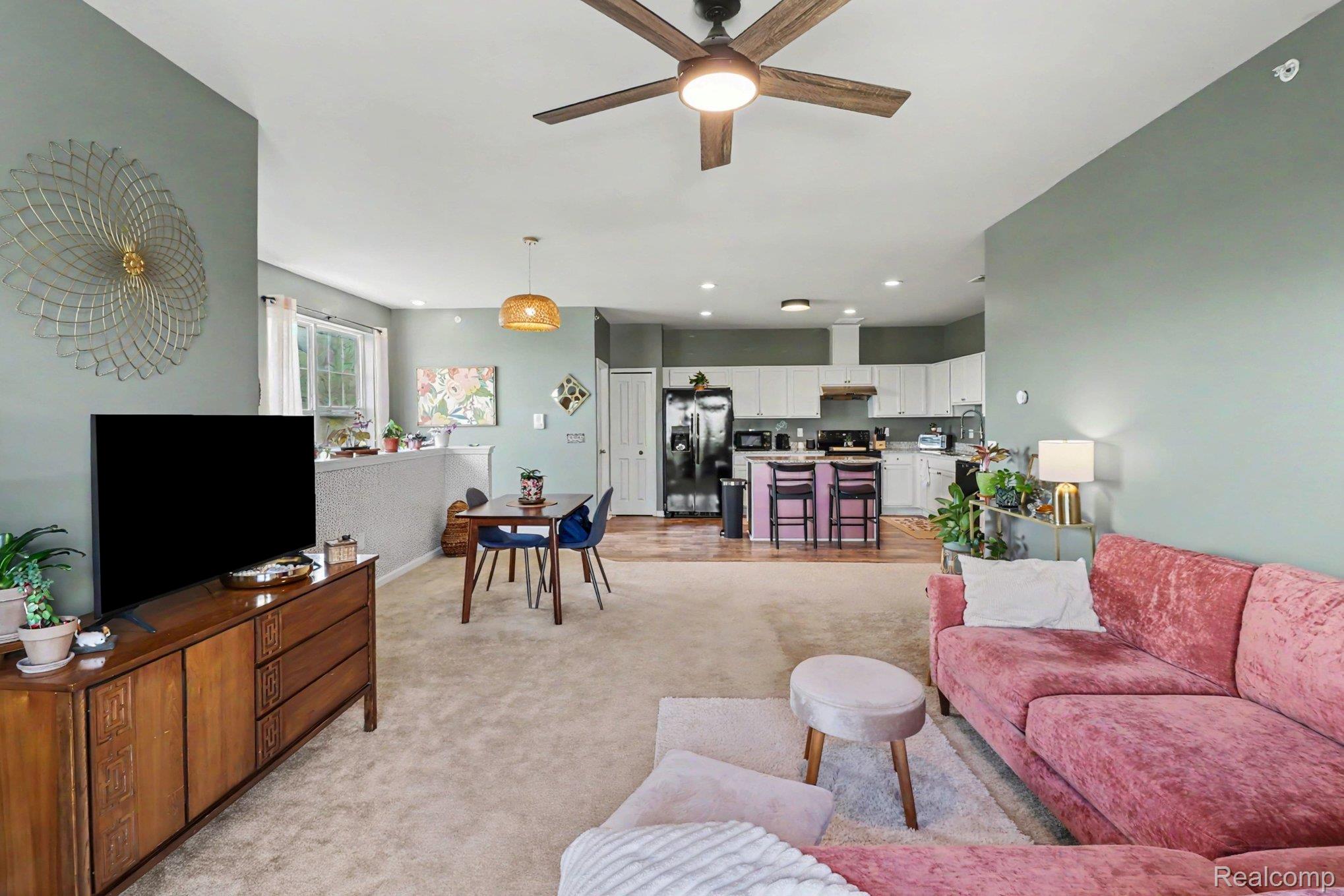 9864 Ridge Run Street Howell, MI 48855 - Photo 6 of 23 Living area with light colored carpet and ceiling fan