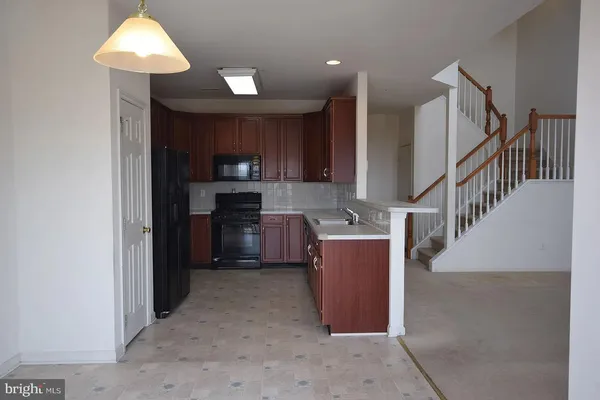 a bedroom with a bed a dresser and a chandelier