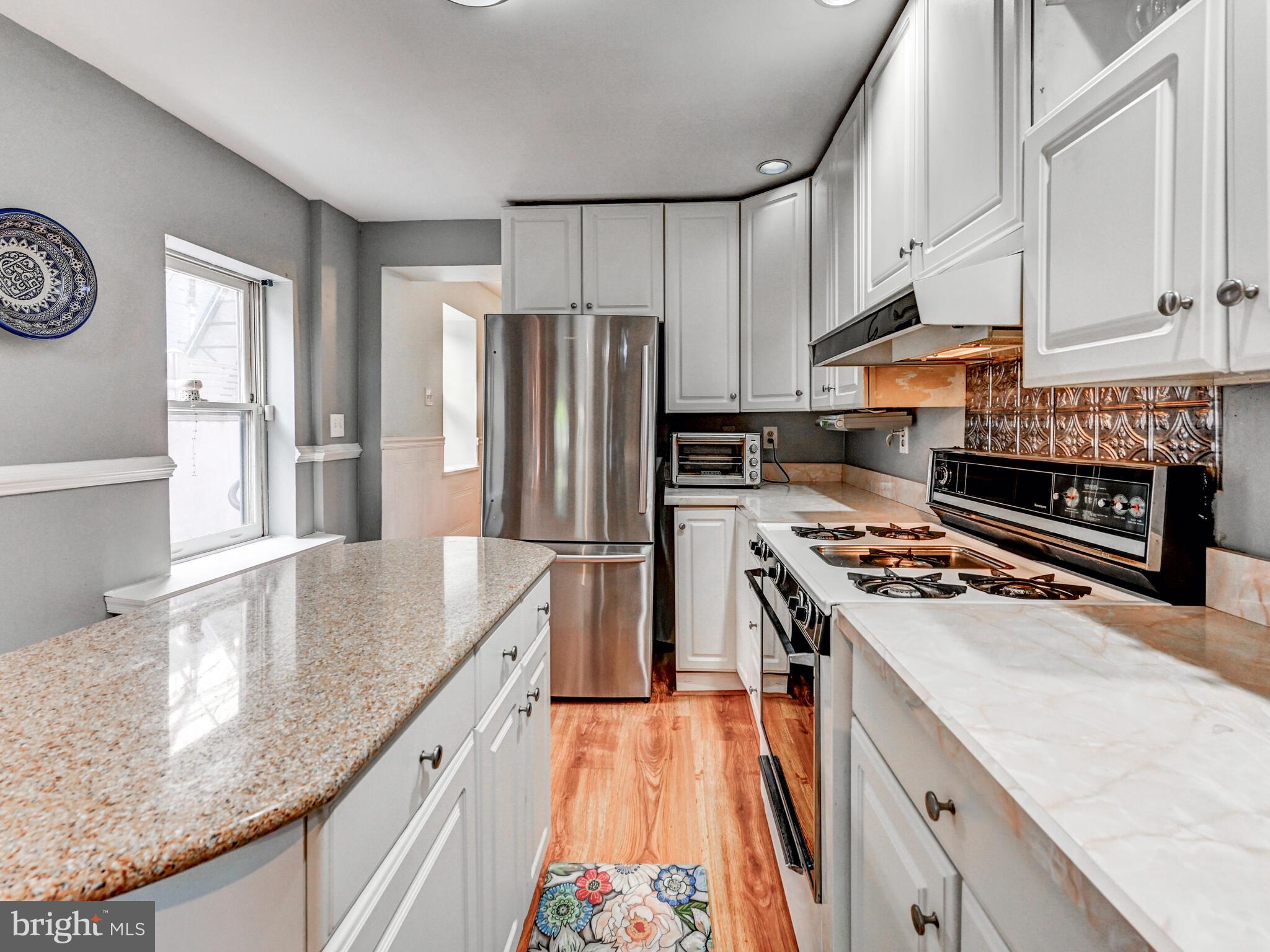 2013 Bank Street Baltimore, MD 21231 - Photo 13 of 38 a kitchen with stainless steel appliances granite countertop a refrigerator a stove and a sink with wooden floor