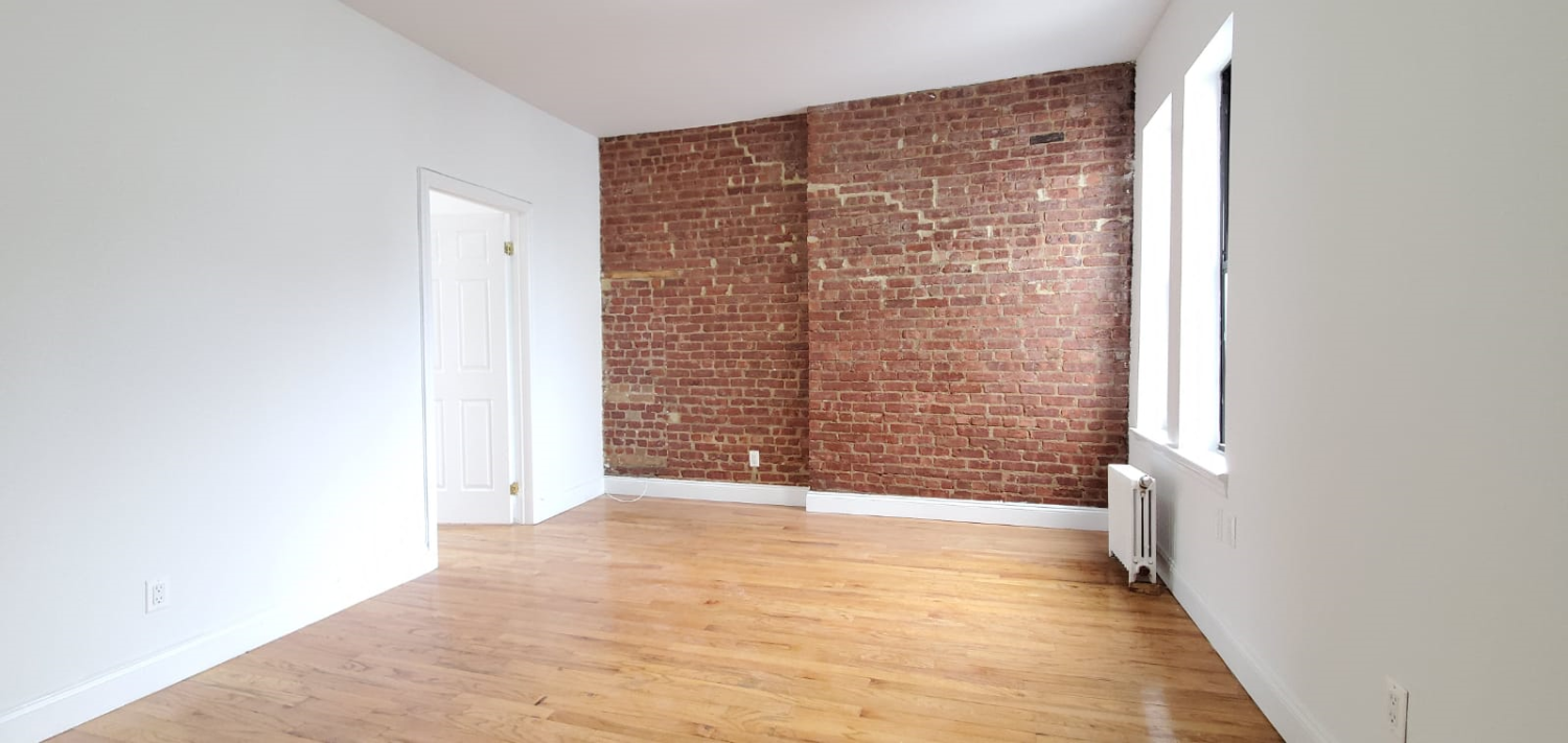 a view of an empty room with brick walls