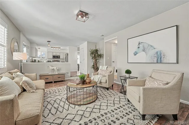 a living room with furniture and a painting on the wall