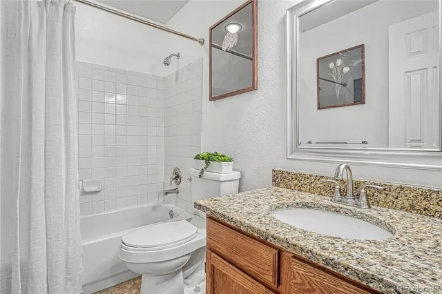 a bathroom with a granite countertop sink toilet and shower