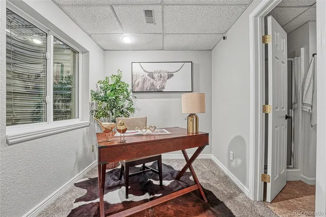 a view of a workspace with furniture and a window
