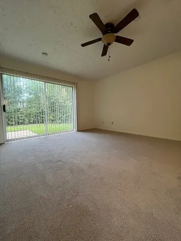 an empty room with a ceiling fan and a window