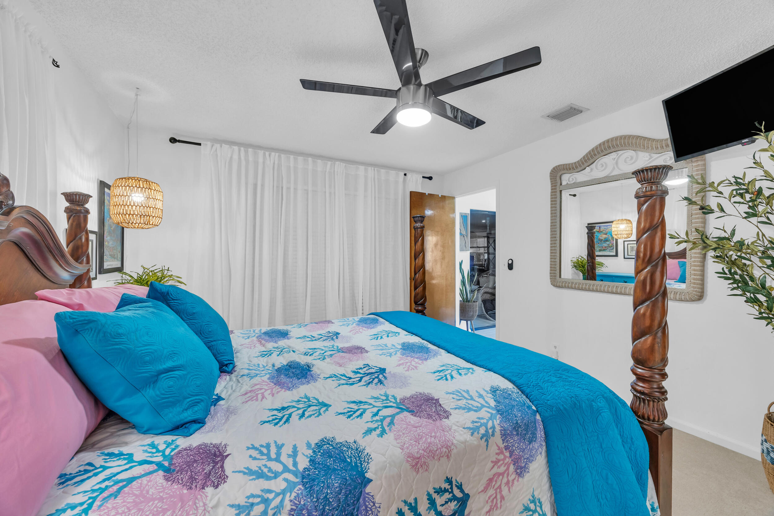 1305 Peninsular Road Jupiter, FL 33469 - Photo 25 of 46 a bedroom with a bed a flat screen tv and a ceiling fan