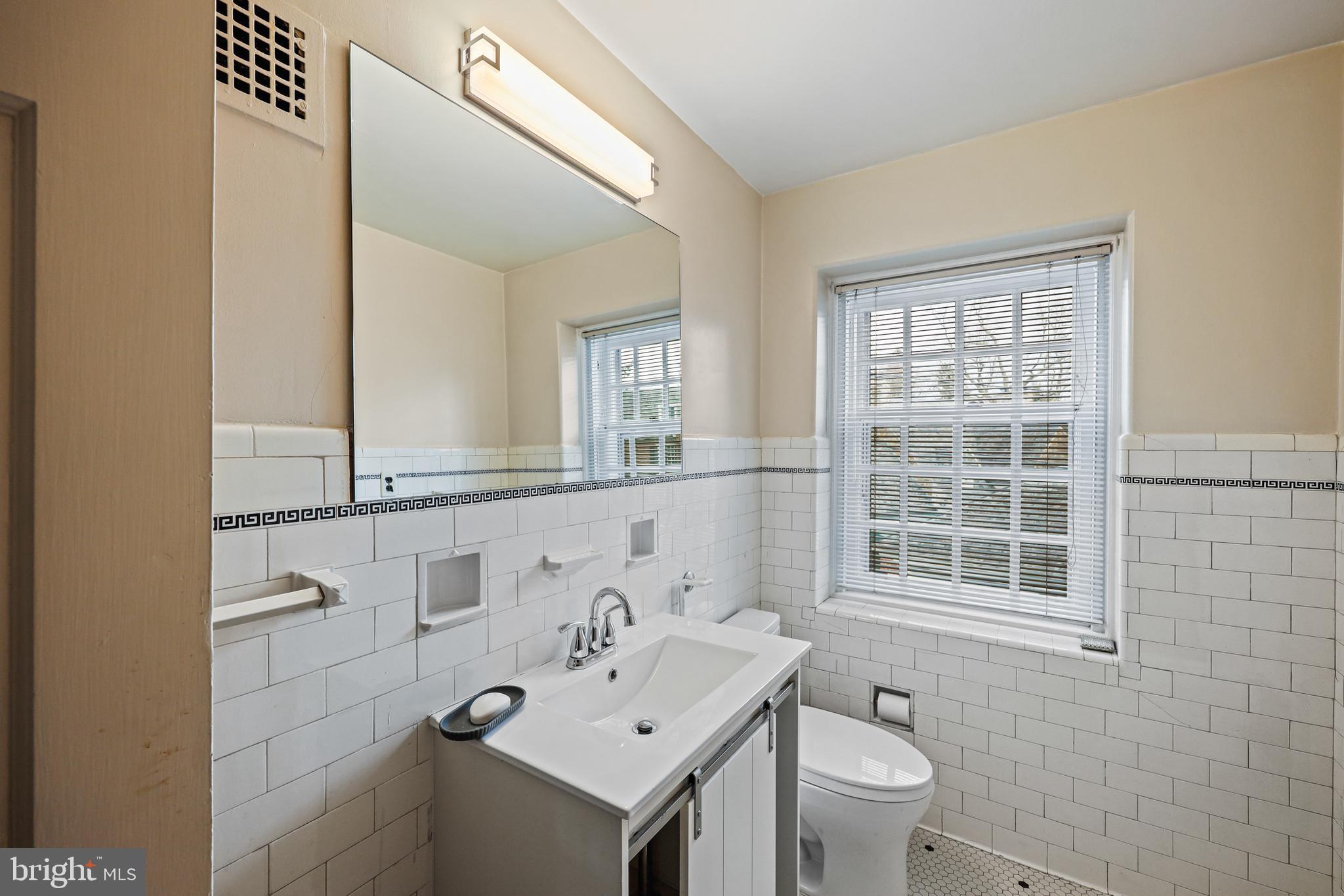 119 St Dunstans Road Baltimore, MD 21212 - Photo 36 of 54 a bathroom with a sink vanity mirror and toilet