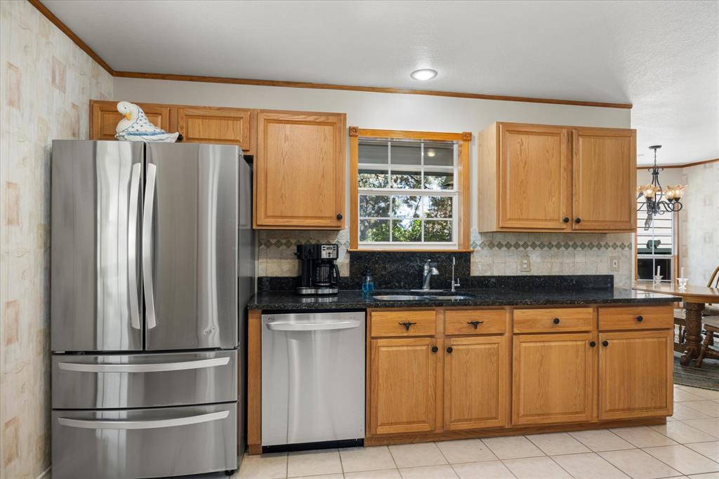 1311 Williamson Road Granbury, TX 76048 - Photo 20 of 40 a kitchen with granite countertop stainless steel appliances a sink and a window