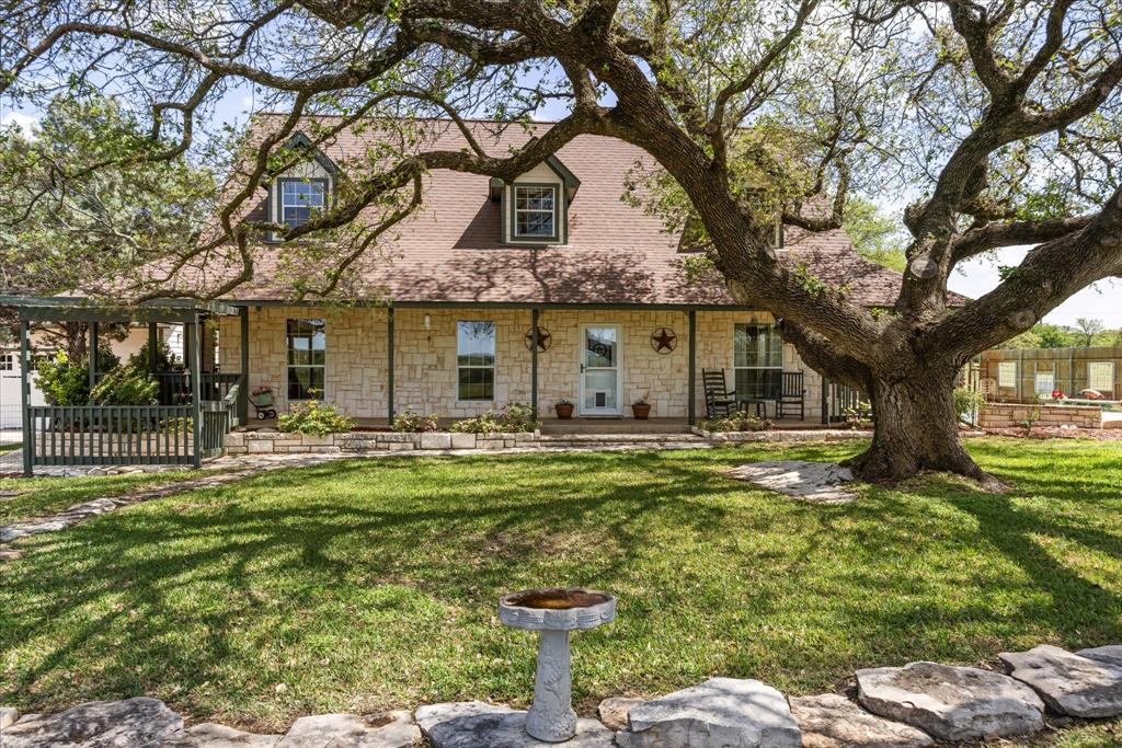 1311 Williamson Road Granbury, TX 76048 - Photo 2 of 40 a front view of a house with a garden and trees