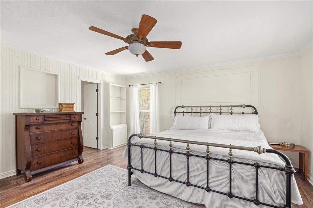 1311 Williamson Road Granbury, TX 76048 - Photo 26 of 40 a bedroom with a bed and a chandelier