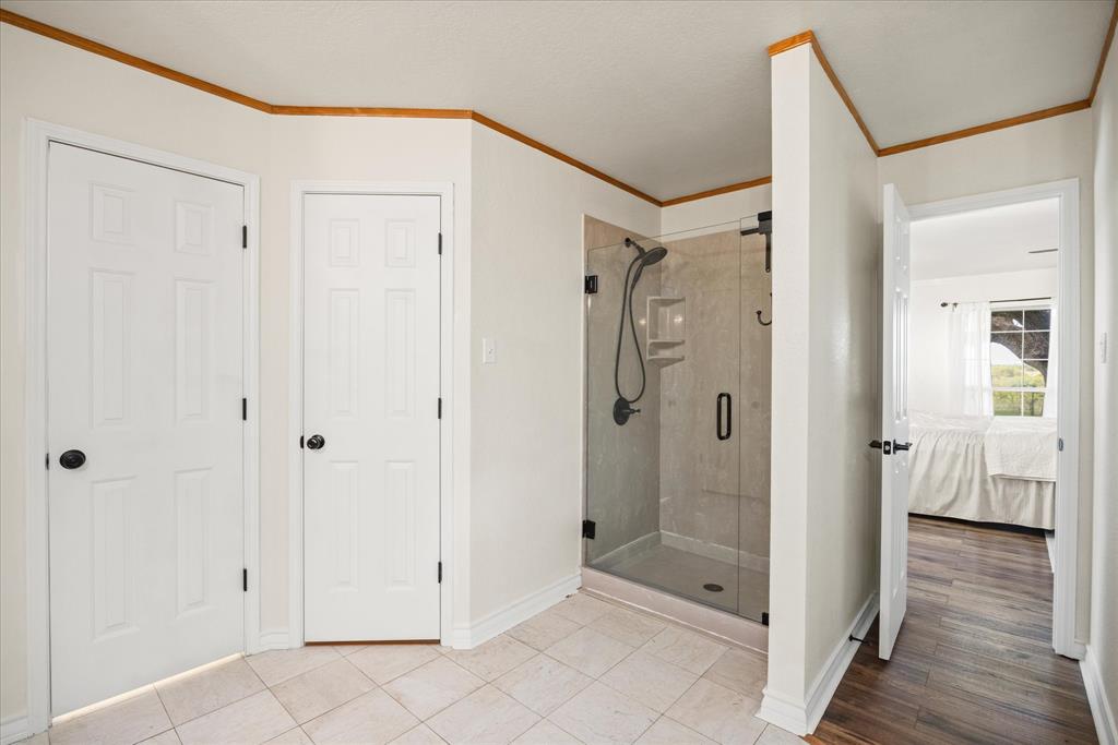 1311 Williamson Road Granbury, TX 76048 - Photo 28 of 40 a bathroom with a shower and a glass door