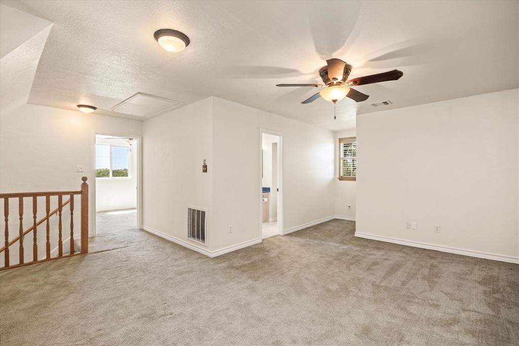 1311 Williamson Road Granbury, TX 76048 - Photo 29 of 40 an empty room with chandelier fan and windows