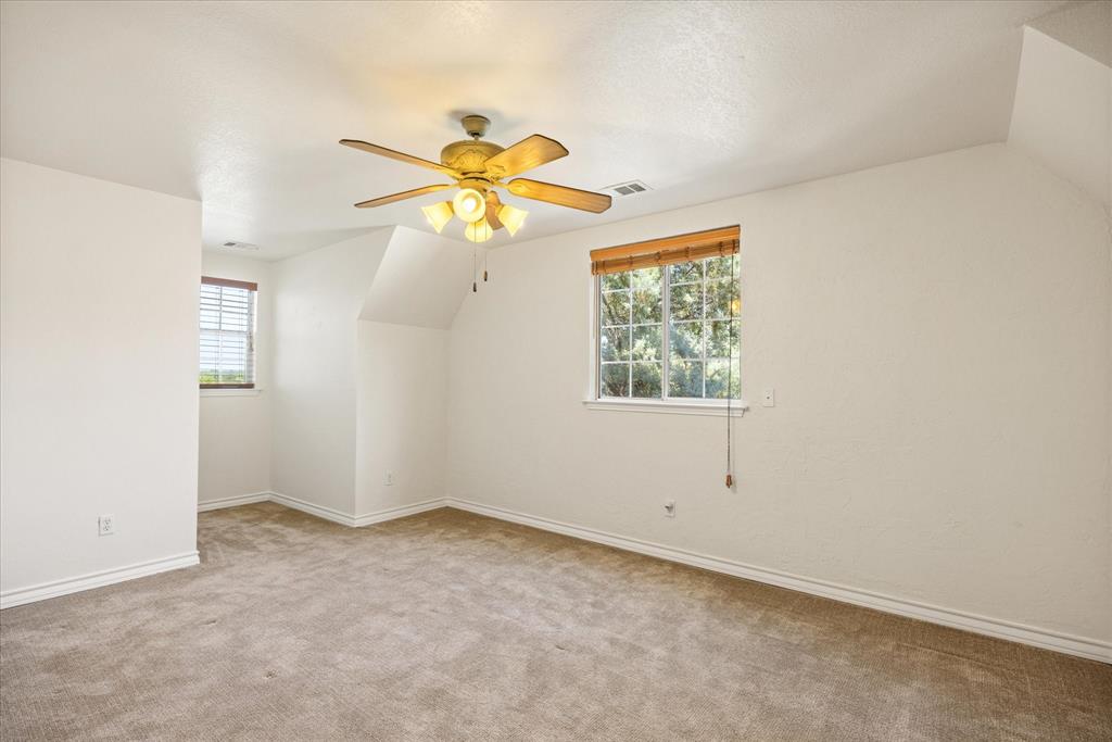1311 Williamson Road Granbury, TX 76048 - Photo 31 of 40 an empty room with windows and a chandelier fan