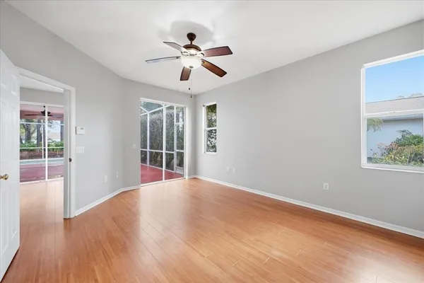 a view of an empty room with wooden floor and a window