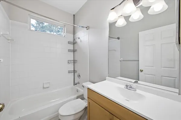 a bathroom with a sink a toilet a mirror and shower