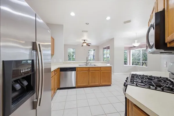 a kitchen with stainless steel appliances granite countertop a sink a stove a microwave a sink and a refrigerator