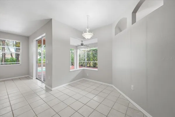 an empty room with windows and chandelier