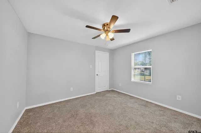 a view of a room with a ceiling fan and a window