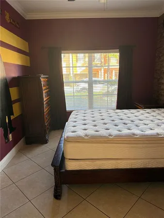 a bedroom with a bed and a dresser next to a window