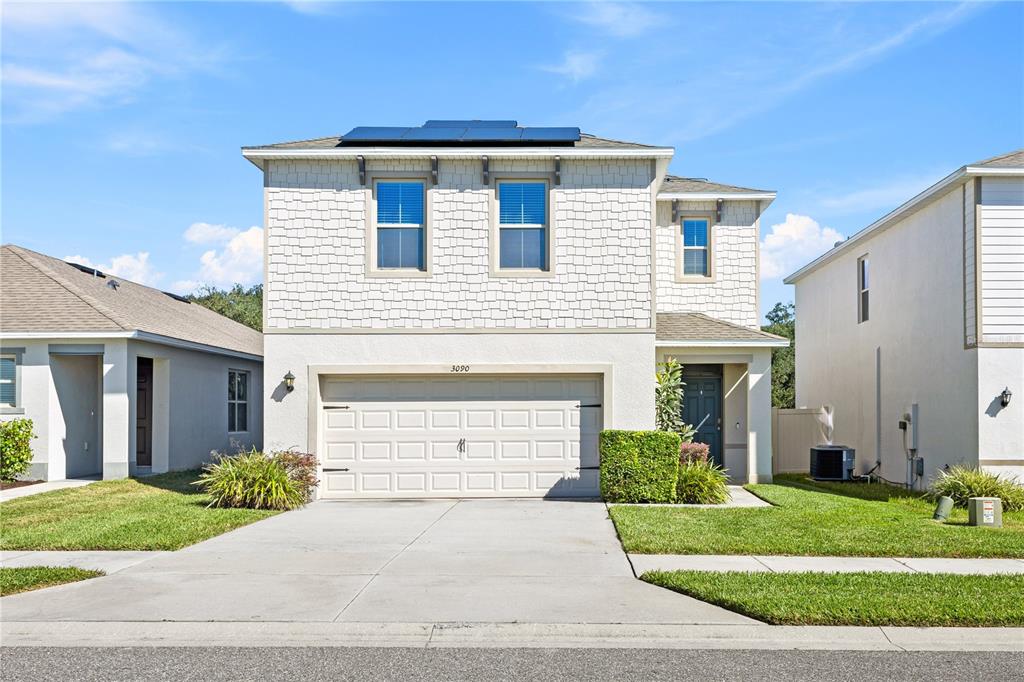 a front view of a house with a yard and garage