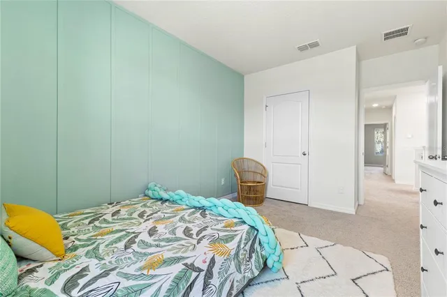 a bedroom with a bed a dresser and with window