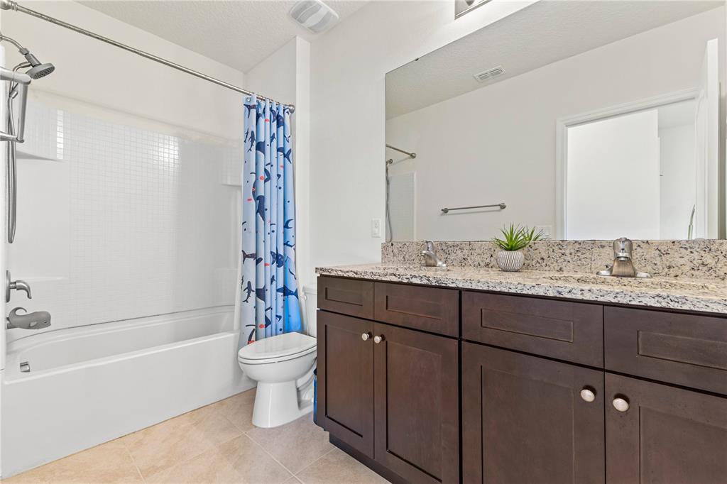 3090 Timber Hawk Circle Ocoee, FL 34761 - Photo 29 of 54 a bathroom with a granite countertop sink a toilet and shower