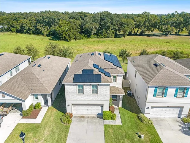 an aerial view of residential houses with outdoor space and parking