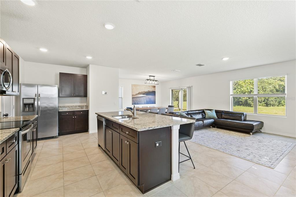 3090 Timber Hawk Circle Ocoee, FL 34761 - Photo 6 of 54 a kitchen with a stove a sink a counter top space and living room