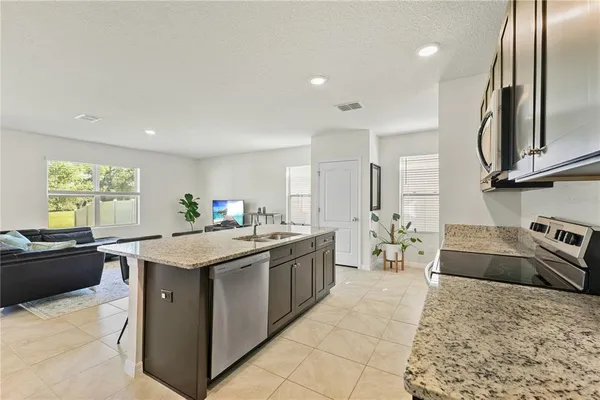 a kitchen with stainless steel appliances granite countertop a sink stove and cabinets