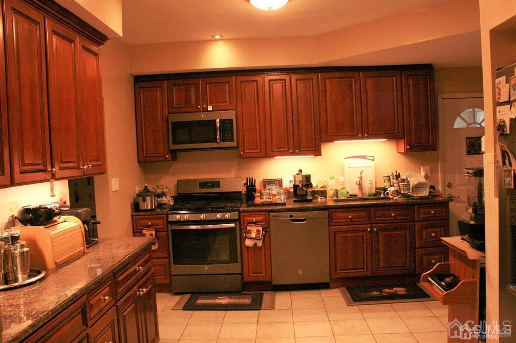 1120 New Dover Road Edison, NJ 08820 - Photo 3 of 9 a kitchen with granite countertop wooden cabinets and stainless steel appliances