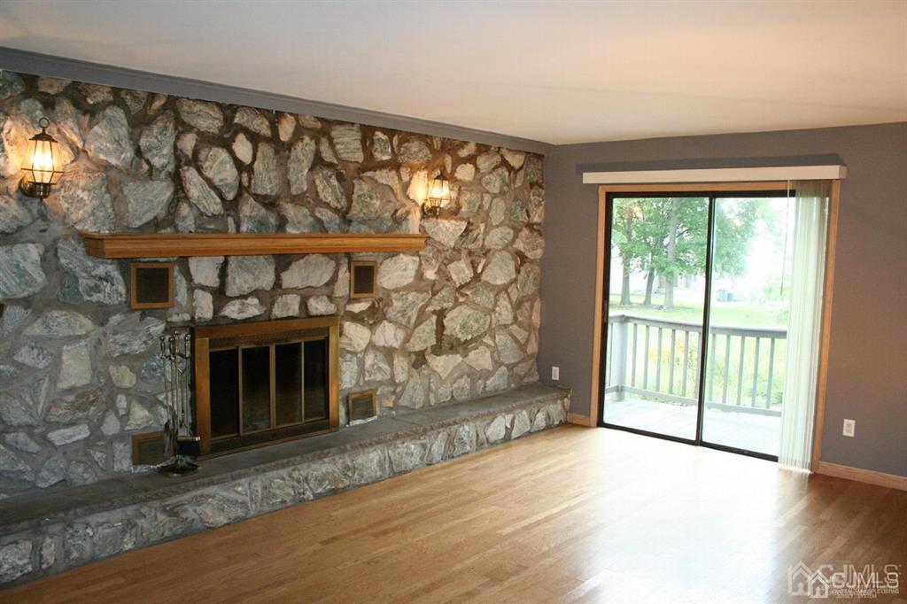 1120 New Dover Road Edison, NJ 08820 - Photo 6 of 9 a view of an empty room with wooden floor and a fireplace