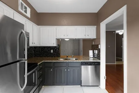 a kitchen with stainless steel appliances granite countertop a refrigerator and a sink