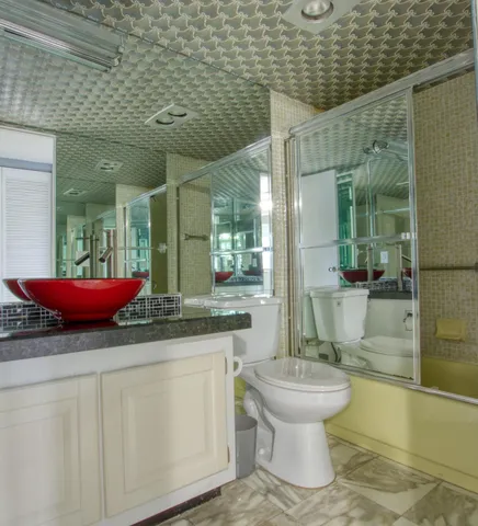 a bathroom with a toilet a sink and mirror