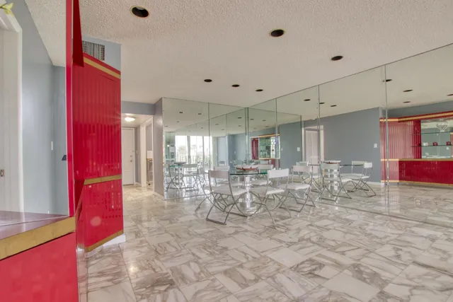 a room with lots of white furniture and glass door