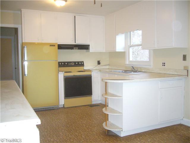 Kitchen. The kitchen is very open and includes a dining area.  The cabinetry is freshly painted and the owner will consider replacing the counter tops and appliances with an acceptable offer.