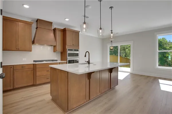 a kitchen with stainless steel appliances a sink stove and wooden floor