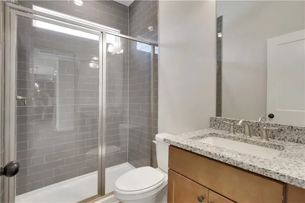 a bathroom with a granite countertop sink toilet and shower