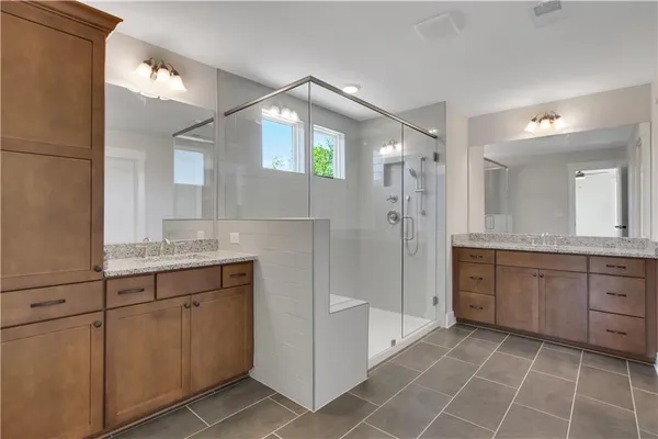 a bathroom with a granite countertop sink mirror and a shower