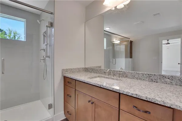a bathroom with a granite countertop sink and a mirror