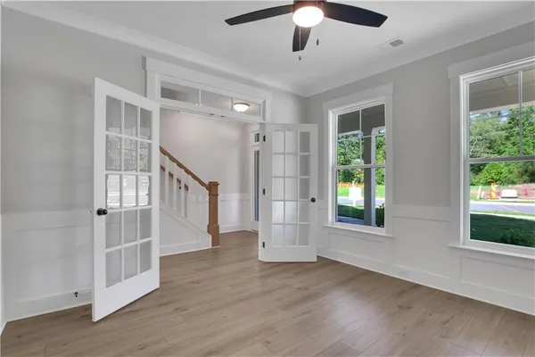 an empty room with wooden floor and windows