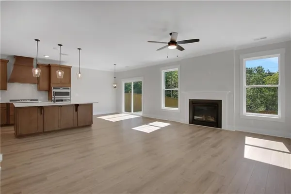 a view of kitchen with granite countertop a fireplace a flat screen tv and a window