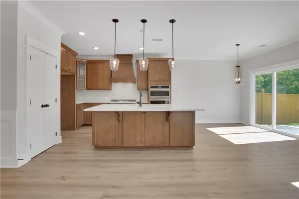 a view of kitchen with stainless steel appliances granite countertop wooden floors