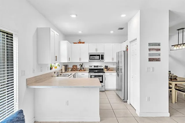 a kitchen with white cabinets and white appliances