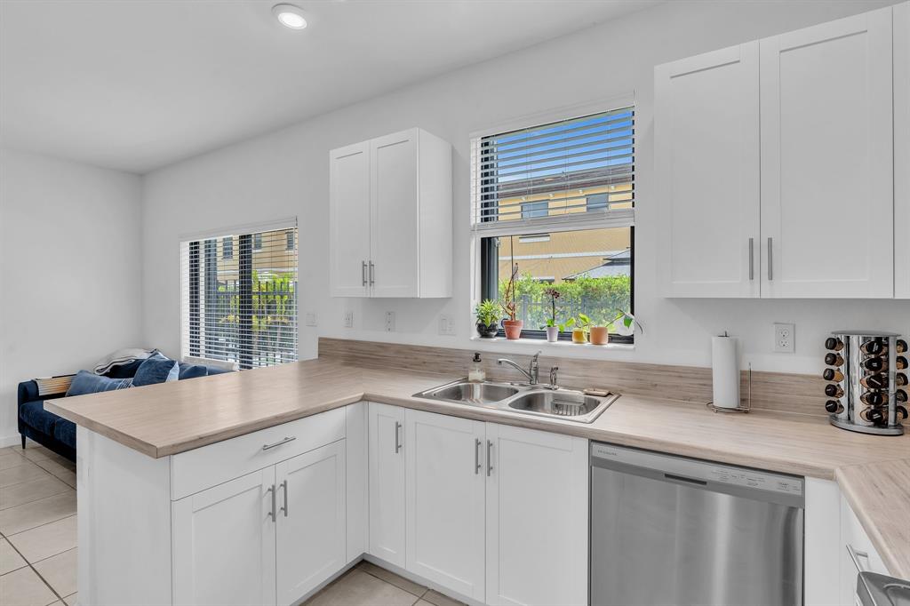 4668 Banker Terrace Davie, FL 33314 - Photo 27 of 52 a kitchen with stainless steel appliances white cabinets a sink and a window