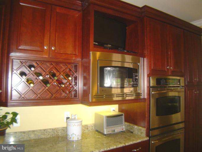 4908 Round Hill Road Frederick, MD 21702 - Photo 8 of 24 a kitchen with a wooden floor and a microwave